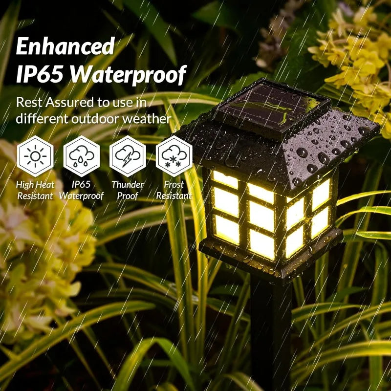 Two solar pathway lights illuminating a garden walkway at dusk