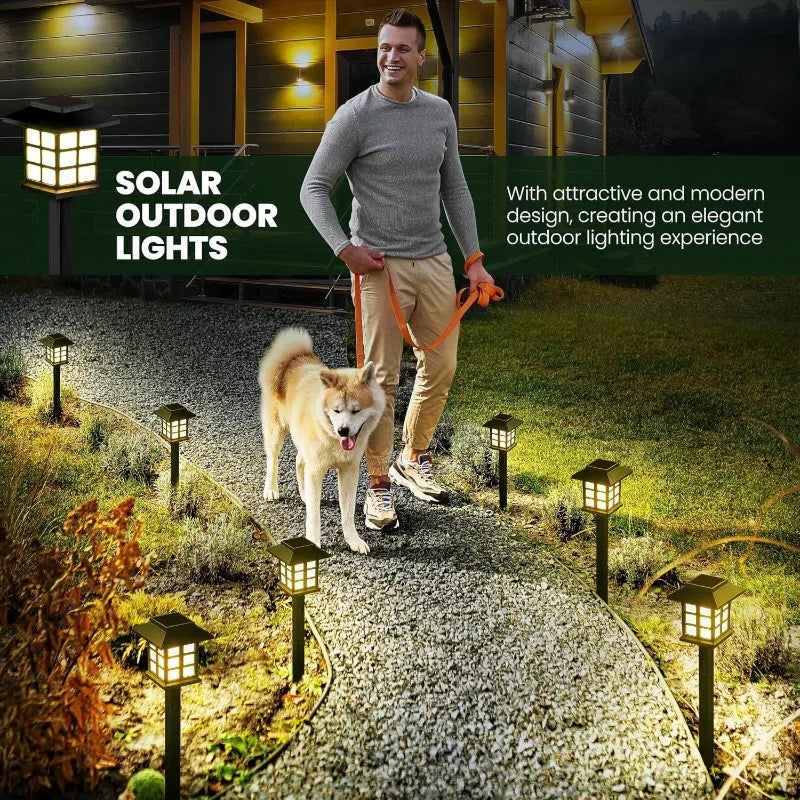Two solar pathway lights illuminating a garden walkway at dusk