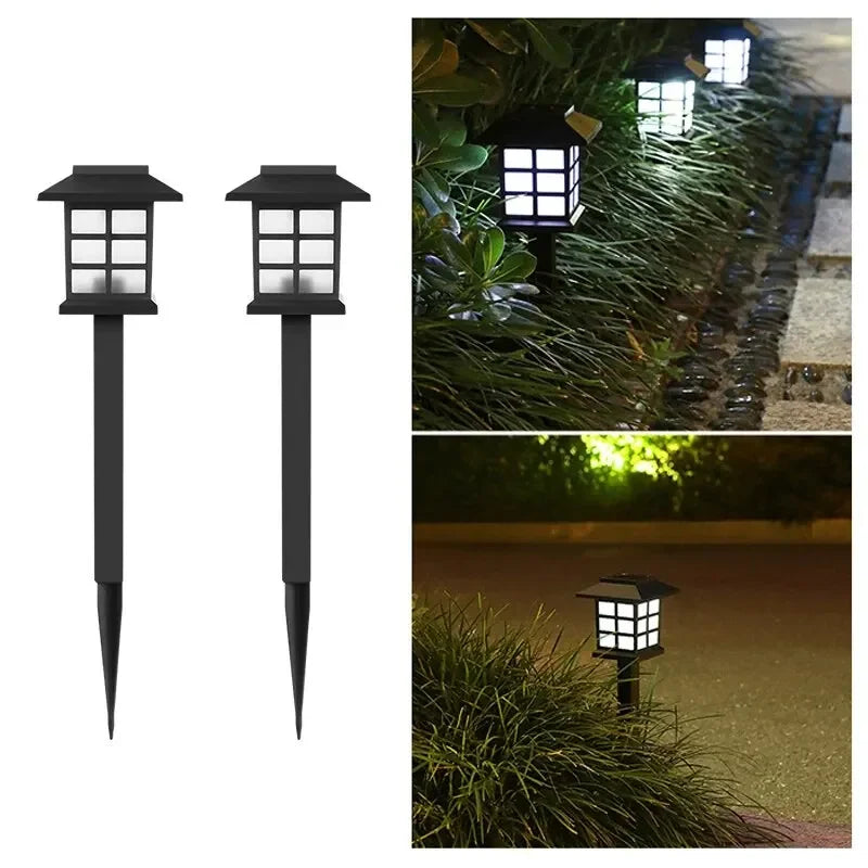 Two solar pathway lights illuminating a garden walkway at dusk