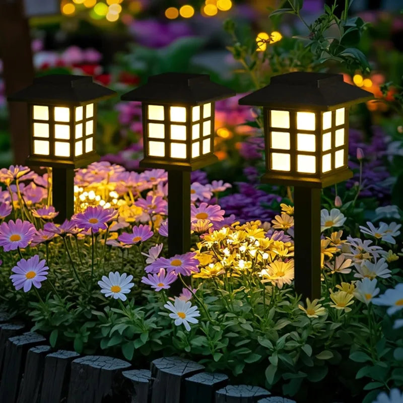Two solar pathway lights illuminating a garden walkway at dusk
